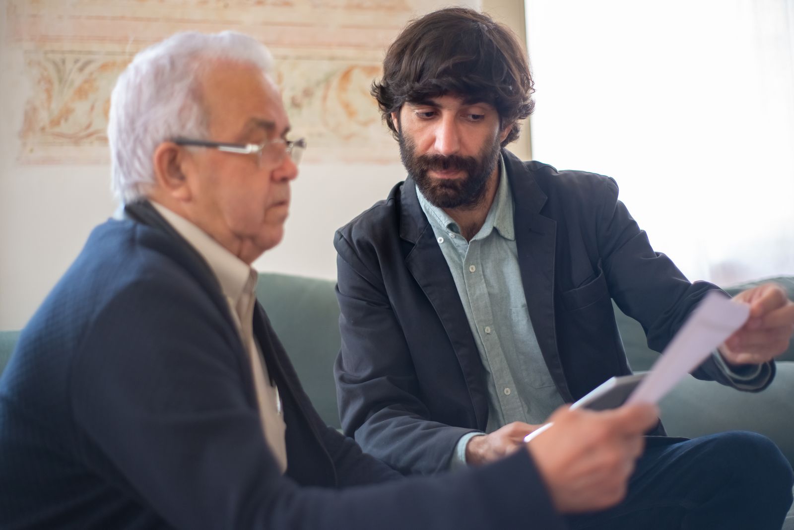 Asesor mostrando un documento a un cliente mayor