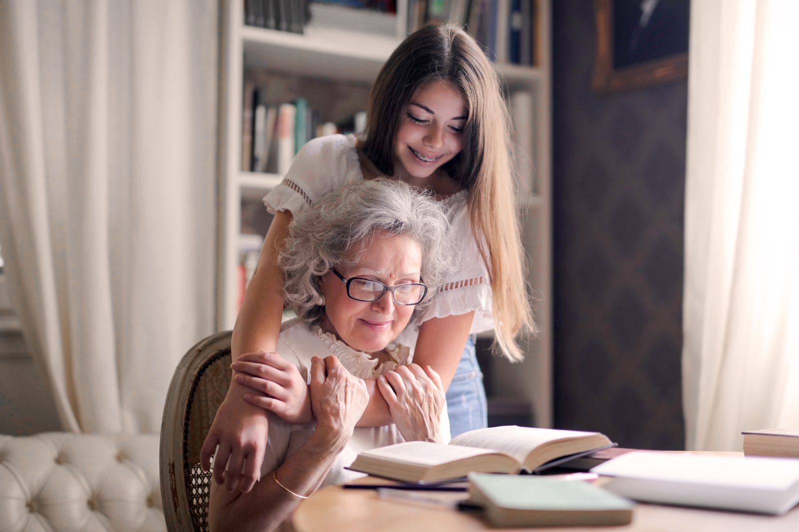 Abuela y nieta leyendo juntas en casa